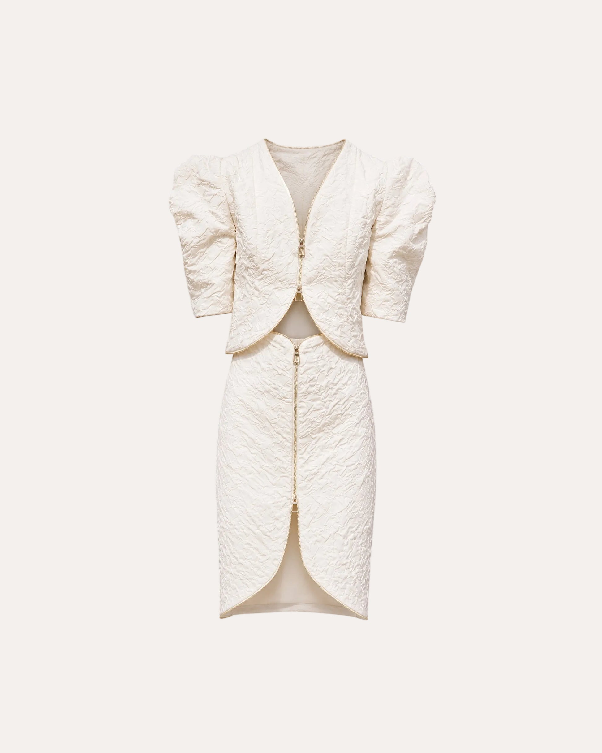 An off-white textured two-piece set featuring a short puff-sleeve jacket and a matching high-slit pencil skirt, both with gold-tone zippers, shown on a plain white background.