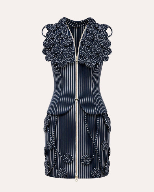 A sleeveless navy blue and white pinstripe mini dress with intricate 3D floral beaded embellishments on the shoulders, waist, and hem, featuring a front zipper.